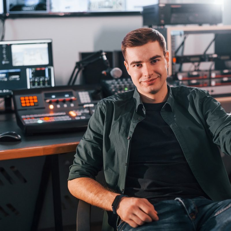 Young man is indoors in the radio studio is busy by broadcast